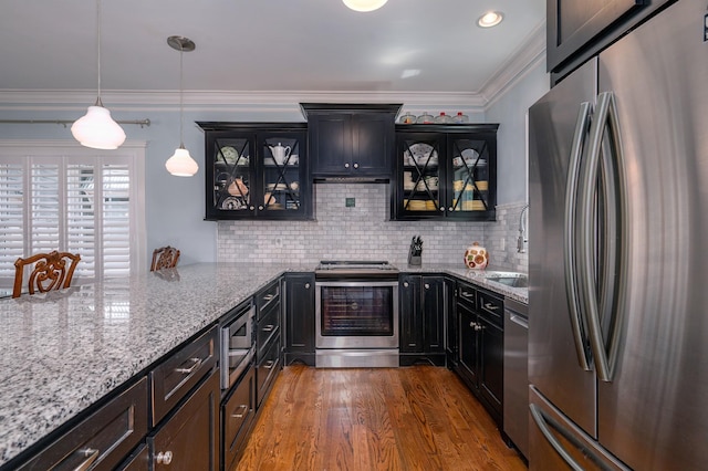bar featuring ornamental molding, pendant lighting, dark wood-style floors, tasteful backsplash, and stainless steel appliances