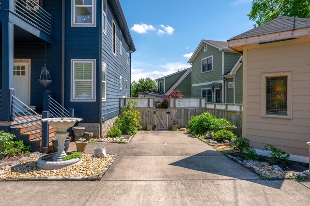 view of side of property featuring fence, a gate, and a patio area