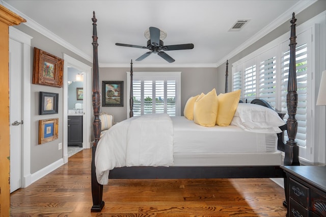 bedroom with crown molding, visible vents, wood finished floors, and connected bathroom