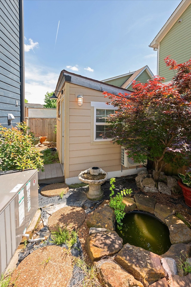 exterior space with a small pond and fence