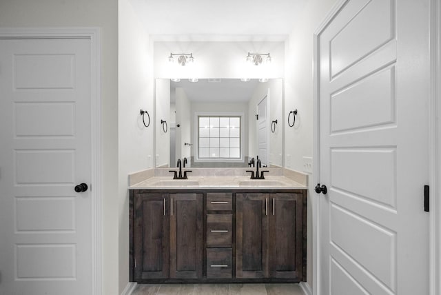 bathroom with a sink and double vanity