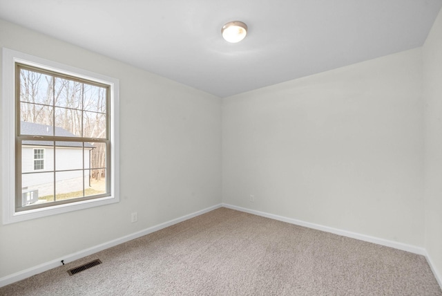 carpeted empty room featuring visible vents and baseboards