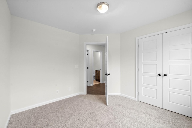 unfurnished bedroom featuring baseboards, carpet flooring, and a closet
