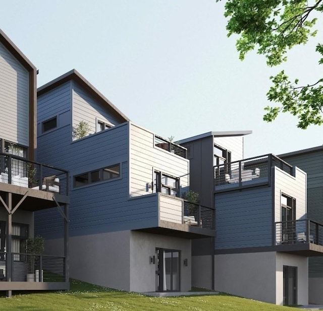 rear view of property with stucco siding and a balcony