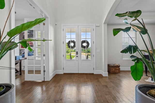 entryway with french doors, arched walkways, wood-type flooring, and baseboards