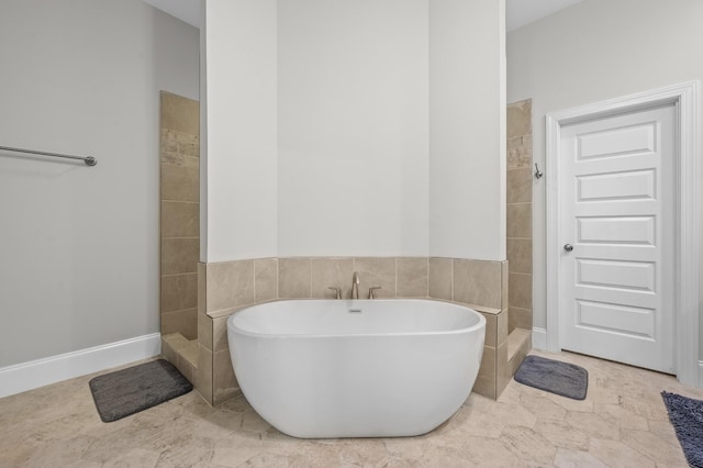 bathroom featuring a freestanding bath and a tile shower