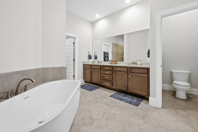 full bath with double vanity, toilet, recessed lighting, a soaking tub, and a sink