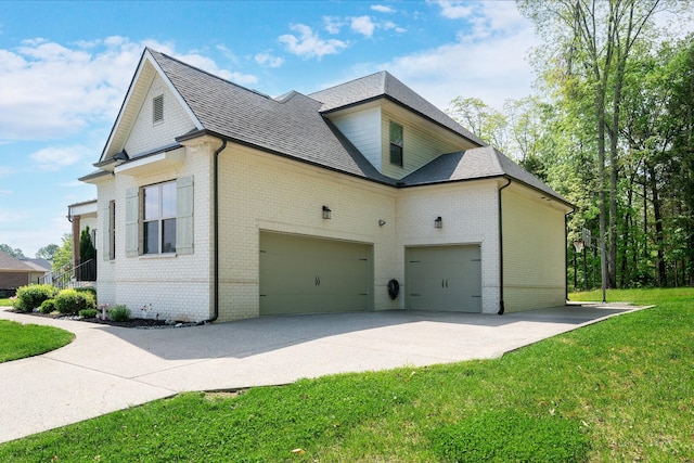 view of side of home featuring a shingled roof, brick siding, a garage, concrete driveway, and a yard