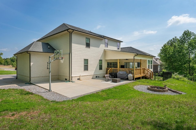 back of house with a deck, a patio, crawl space, an outdoor fire pit, and a yard