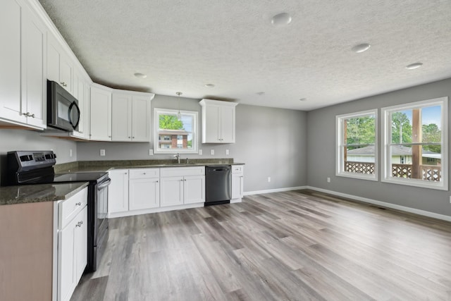 605 Poplar St, Lafayette, TN 37083 - kitchen featuring a textured ceiling, baseboards, black appliances, and light wood-type flooring