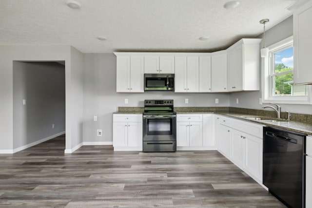 605 Poplar St, Lafayette, TN 37083 - kitchen with dark stone countertops, a textured ceiling, a sink, dark wood finished floors, and appliances with stainless steel finishes