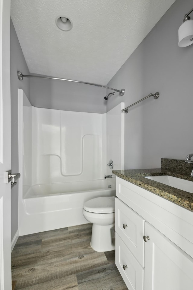 605 Poplar St, Lafayette, TN 37083 - bathroom with vanity, wood finished floors, bathing tub / shower combination, toilet, and a textured ceiling