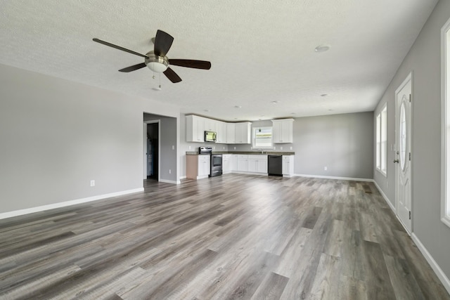 605 Poplar St, Lafayette, TN 37083 - unfurnished living room with a textured ceiling, baseboards, ceiling fan, and wood finished floors