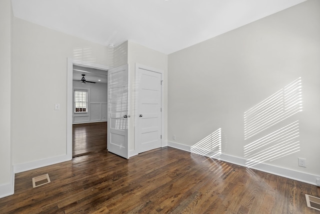 unfurnished bedroom featuring baseboards, dark wood finished floors, and visible vents