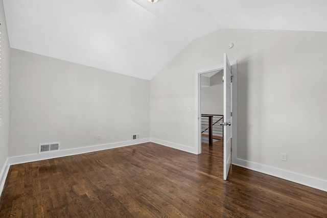 interior space with lofted ceiling, dark wood-style floors, and visible vents