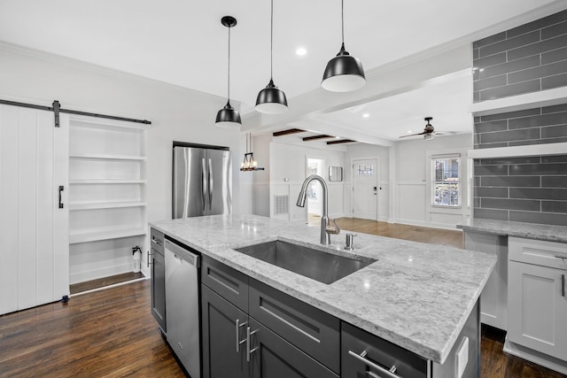 kitchen featuring ornamental molding, dark wood-style flooring, ceiling fan, a sink, and stainless steel appliances