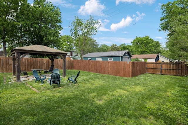 view of yard with a gazebo, a fenced backyard, and a fire pit