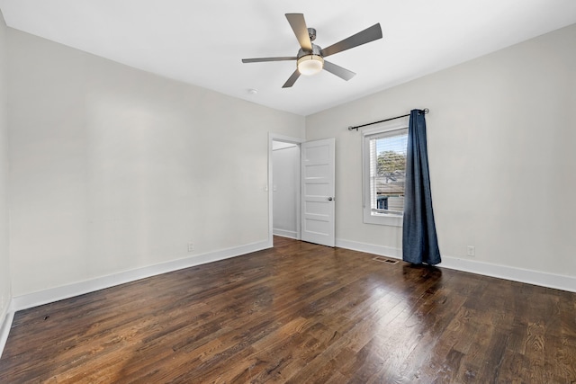 unfurnished bedroom featuring baseboards, ceiling fan, wood finished floors, and visible vents