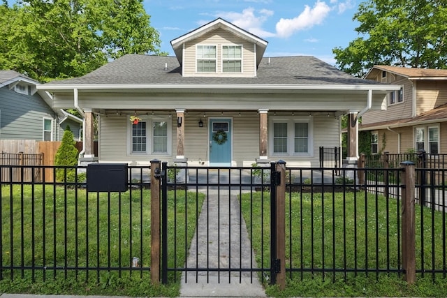 bungalow with a fenced front yard, a porch, and a front yard