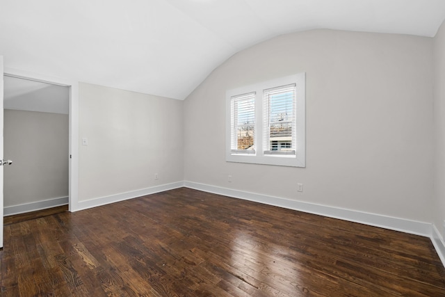 additional living space with baseboards, dark wood-type flooring, and lofted ceiling