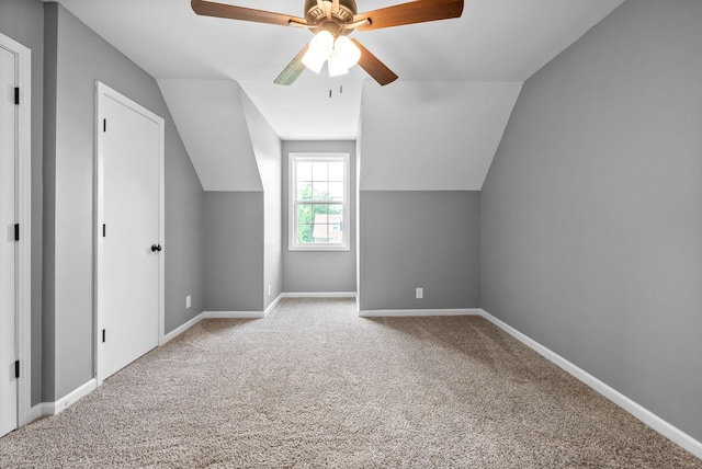 additional living space with ceiling fan, vaulted ceiling, baseboards, and carpet