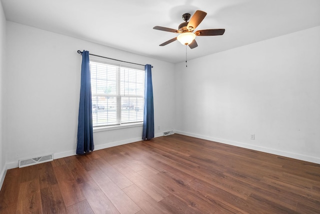 empty room featuring baseboards, a ceiling fan, wood finished floors, and visible vents