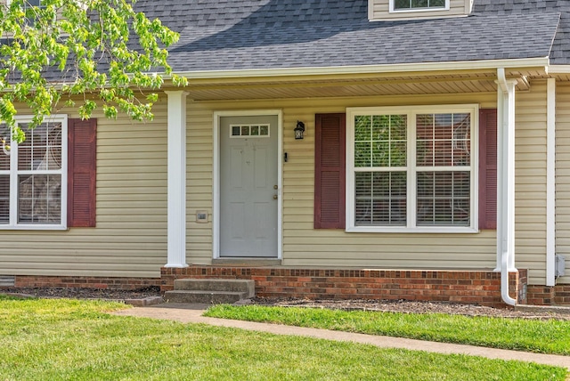 doorway to property featuring a shingled roof