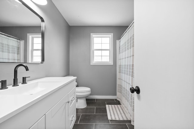 bathroom featuring vanity, baseboards, tile patterned floors, and toilet