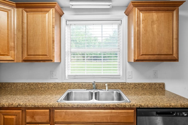 kitchen with a sink, stainless steel dishwasher, and brown cabinets