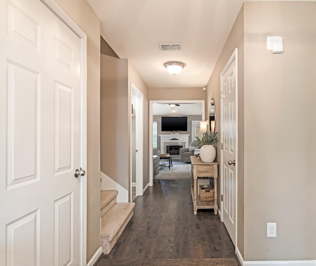 hallway with baseboards, dark wood-type flooring, stairs, and visible vents
