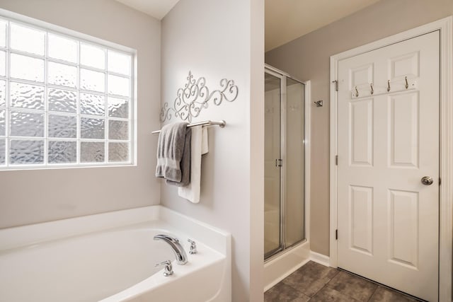 full bathroom featuring tile patterned floors, a shower stall, and a garden tub