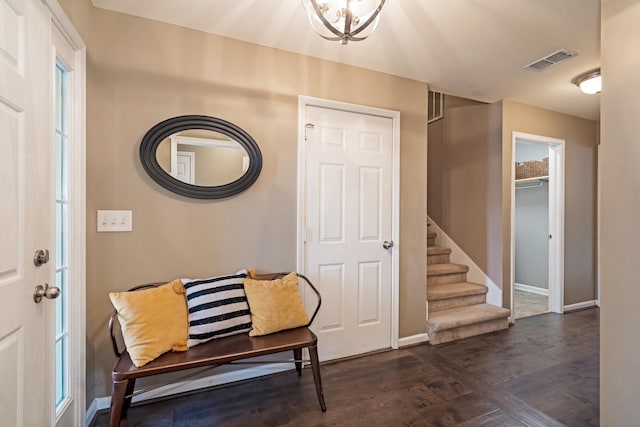 entrance foyer featuring visible vents, baseboards, dark wood-style flooring, and stairway