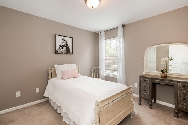 bedroom with baseboards and light carpet
