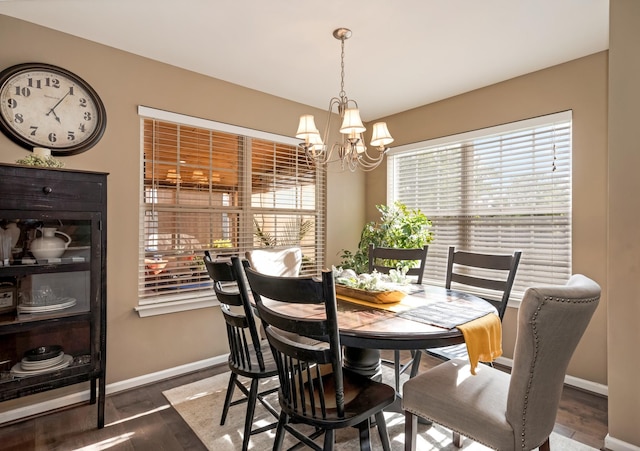 dining room featuring baseboards, wood finished floors, and a chandelier