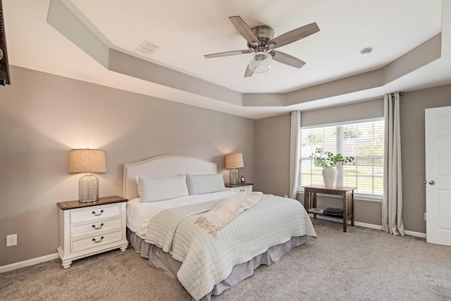 bedroom with baseboards, visible vents, a ceiling fan, and light colored carpet