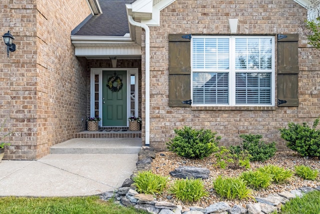 doorway to property featuring brick siding