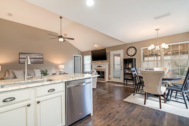 kitchen with a sink, open floor plan, vaulted ceiling, stainless steel dishwasher, and visible vents