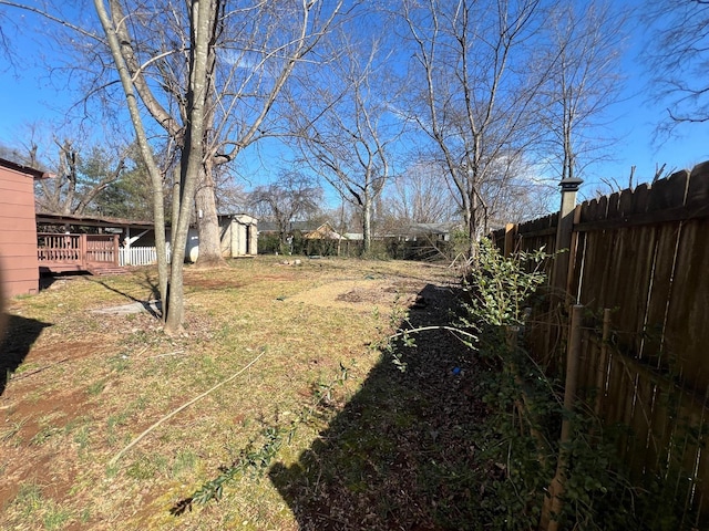 419 Hawkins Ave, Murfreesboro, TN 37130 - view of yard featuring a storage unit, a fenced backyard, a wooden deck, and an outbuilding