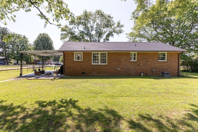 back of house featuring a yard, a patio area, brick siding, and crawl space