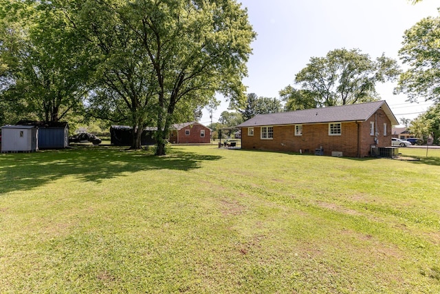 view of yard with a storage unit, central AC unit, and an outbuilding