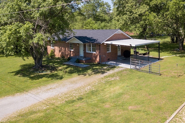 view of front of house with an attached carport, brick siding, a front yard, and dirt driveway