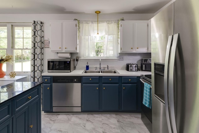 kitchen with a sink, light countertops, stainless steel appliances, white cabinetry, and blue cabinets