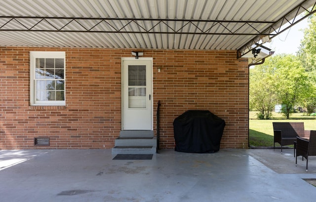 property entrance with visible vents, a patio, and brick siding