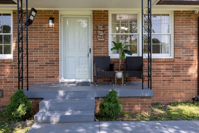 property entrance with brick siding and covered porch