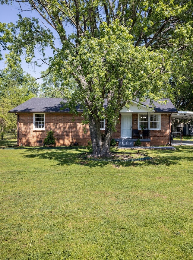 view of front facade with an attached carport, brick siding, crawl space, and a front lawn