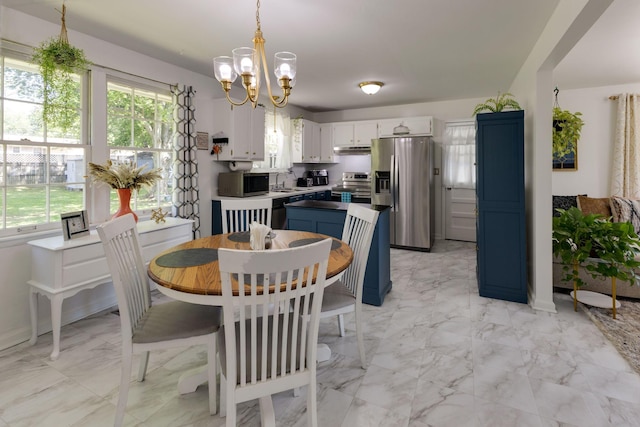 dining space with an inviting chandelier and marble finish floor