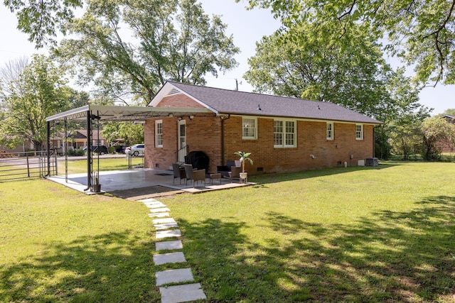 rear view of property with a patio, an attached carport, brick siding, crawl space, and a yard
