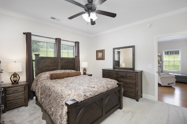 bedroom featuring light carpet, a ceiling fan, baseboards, visible vents, and ornamental molding