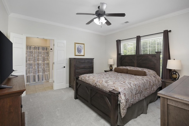 bedroom featuring crown molding, light colored carpet, a ceiling fan, ensuite bathroom, and visible vents