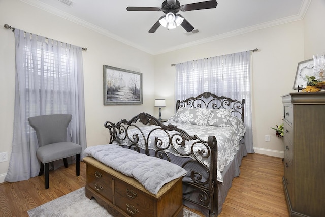 bedroom with crown molding, visible vents, multiple windows, and light wood-style floors